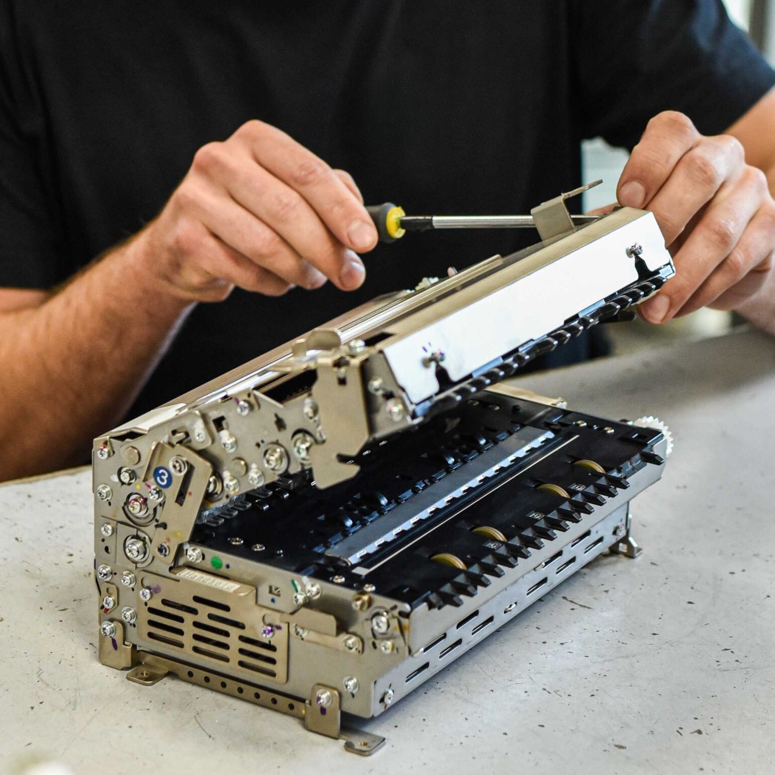 man fixing ATM parts with srewdriver